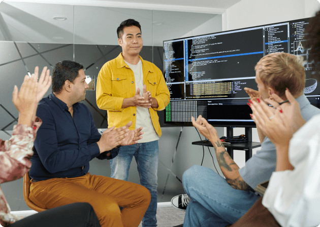 Vibrant Logics team huddled around a monitor during a code review